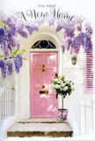 This scene shows a perfectly composed new-home moment outside a pretty Highams Park doorway, the sort of entrance you might discover while strolling from Chingford Mount Road towards the leafy paths by the lake. The focal point is a front door painted in a soft, warm pink, its gentle tone radiating friendliness and inviting you closer. Framing the door and upper wall, wisteria drapes richly in tumbling strands of lavender and lilac, each blossom hanging in loose clusters that suggest a delicate fragrance, sweet and slightly powdery, drifting on the breeze. The surrounding wall is whitewashed, with a lightly painted shutter that picks up the same rosy undertone as the door, creating a consistent, pastel palette that feels calm and uplifting. At the foot of the doorway, a chic, grey-tinted bucket rests on the step, carefully positioned as if just delivered by a thoughtful friend. It brims with lush white and cream roses, their petals thick and velvety, some tightly curled, others unfolding to full, cup-shaped blooms. Sprays of soft green foliage wind gently between the roses, adding depth, movement, and a natural, garden-fresh character. Around the base of the bucket, a satin ribbon in blush pink is tied in a simple, elegant bow, its long tails lying softly against the metal and stone. The light is soft and flattering, suggesting late afternoon or early evening, and lends the entire composition a gentle glow. The mood is one of quiet celebration and promise-the ideal floral vignette for marking a new address in Highams Park, welcoming loved ones, and honouring the tender excitement of starting a new chapter.
